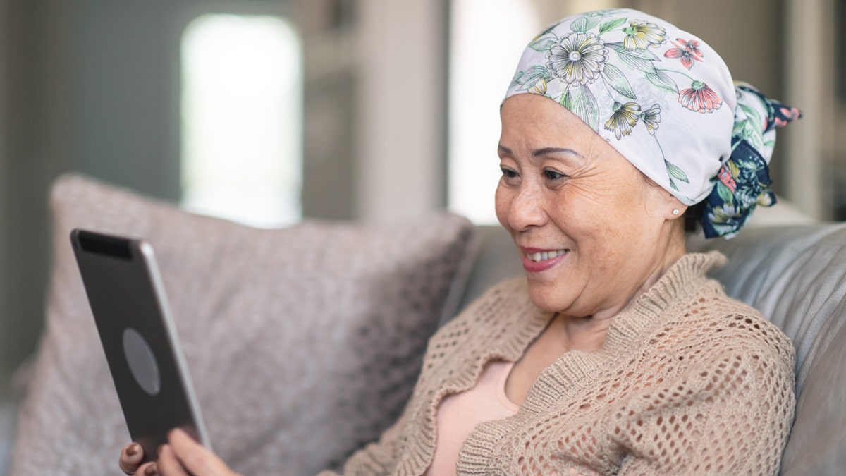 Woman with cancer on tablet