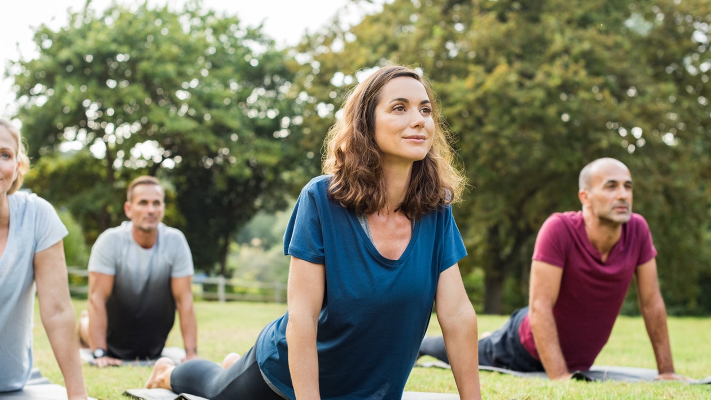 people doing yoga in park