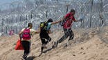 Immigrants push through razor wire after crossing from Mexico into El Paso, Texas, on May 11, 2023.
