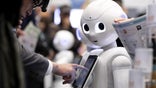 An attendee tries out an application on a SoftBank Group Corp. Pepper humanoid robot at the SoftBank Robot World 2017 in Tokyo, Japan, on Tuesday, Nov. 21, 2017. SoftBank Chief Executive Officer Masayoshi Son has put money into robots, artificial intelligence, microchips and satellites, sketching a vision of the future where a trillion devices are connected to the internet and technology is integrated into humans.  Photographer: Kiyoshi Ota/Bloomberg via Getty Images