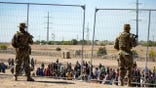 Border Patrol agents stand in front of gate