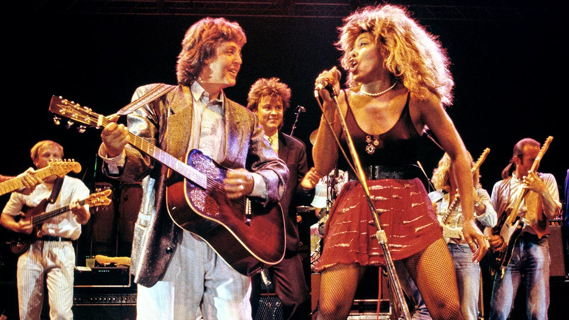Paul McCartney and Tina Turner performing together on stage.