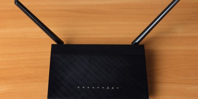 Black wifi router on a wooden desk