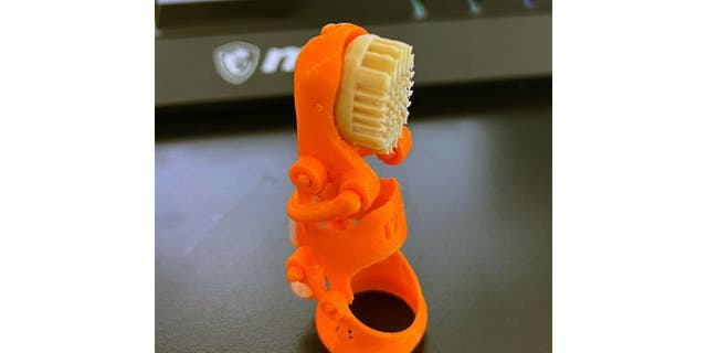 Orange pinky 3D-printed prosthetic finger 