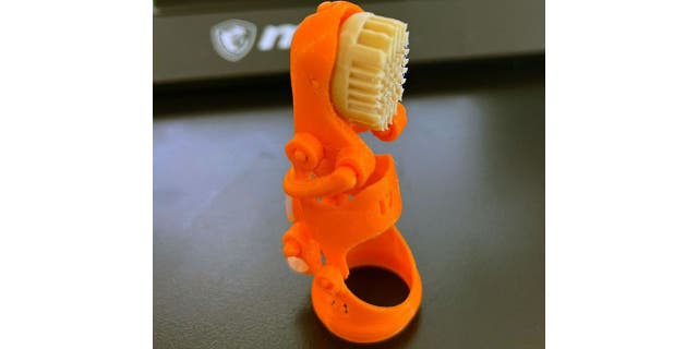 Orange pinky 3D-printed prosthetic finger 