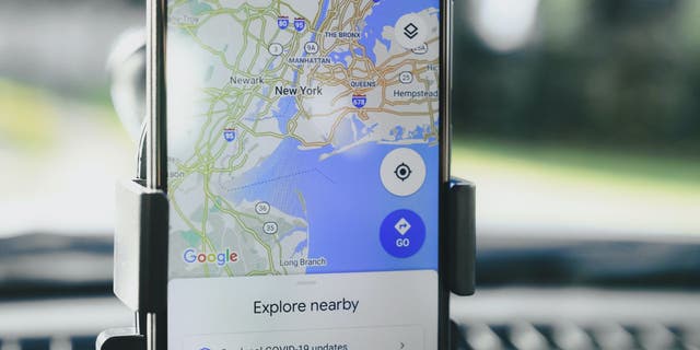 Gambar Google Maps ditarik dan dibuka di telepon duduk di dudukan telepon di dalam mobil