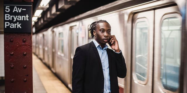 Man talks on his phone while at a subway station