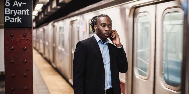 Man talks on his phone while at a subway station