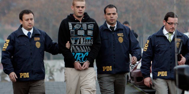 Joran Van der Sloot is escorted by police officers to the airport in Santiago