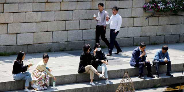 People walk on a sunny spring day in Seoul