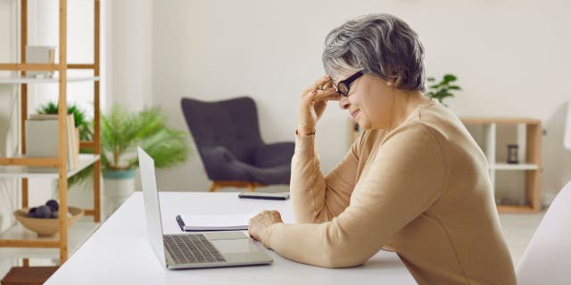 Frustrated woman works on computer