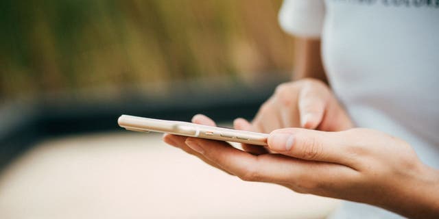 Up close hands of woman holding iPhone