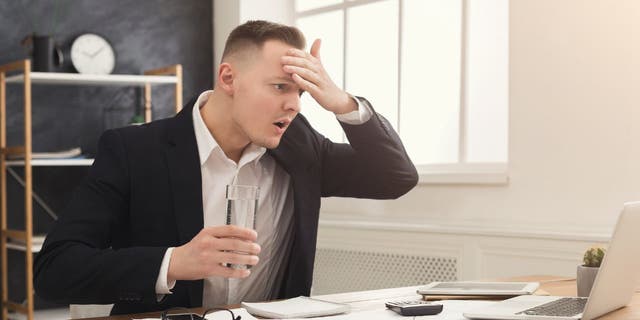 A picture of a man stressed out on his computer