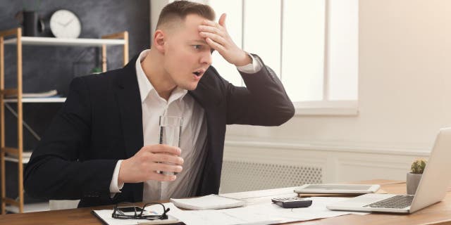 A picture of a man stressed out on his computer