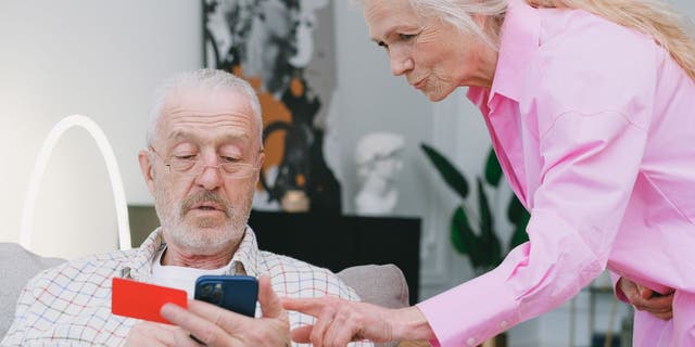 Old couple looks at iphone