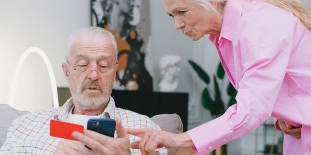 Old couple looks at iphone