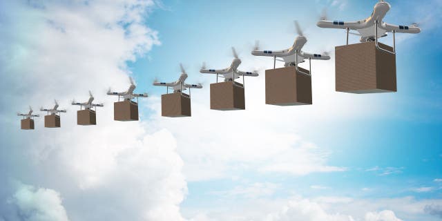 Birden fazla dron, gökyüzündeyken kutuları taşır