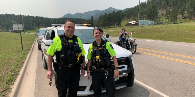 Croix County Sheriff’s Office Deputy Kaitie Leising poses next to another deputy with mountains in the background