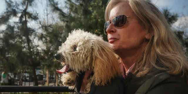 Colleen Briggs sostiene a su caniche de 8 meses llamado Bondi