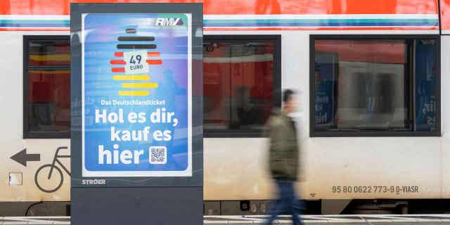 A man passes by an advertising for the Deutschlandticket