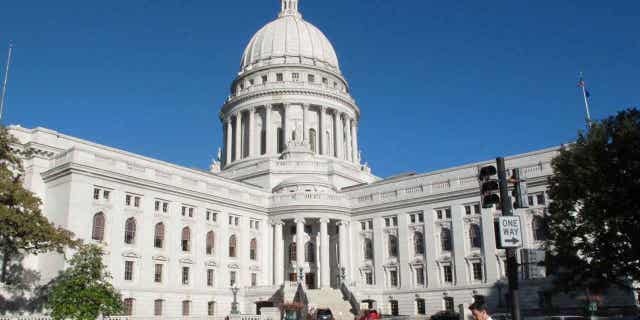 A man walks by the Wisconsin state Capitol,