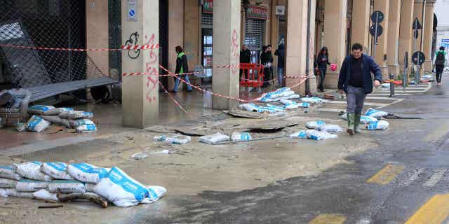 Mud and sand bags lie on the side of a street