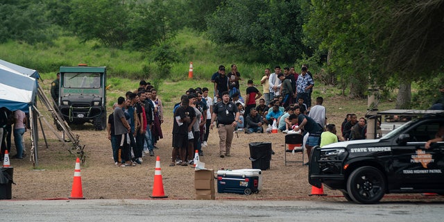 Migrants line up by Brownsville border