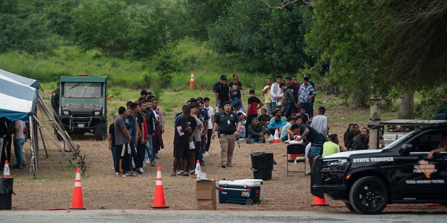 Migrants line up by Brownsville border