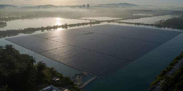 The sun rises over floating solar panels