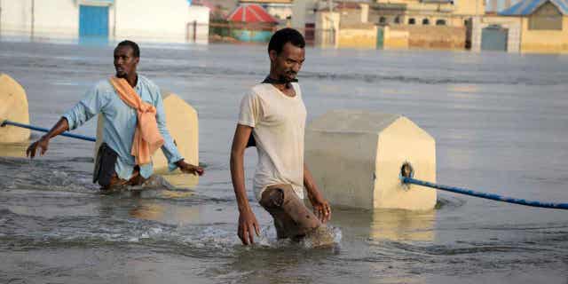 Men walking through floodwaters