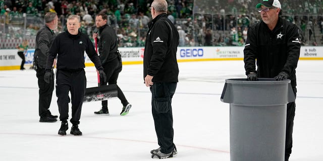 Workers clear debris off the ice