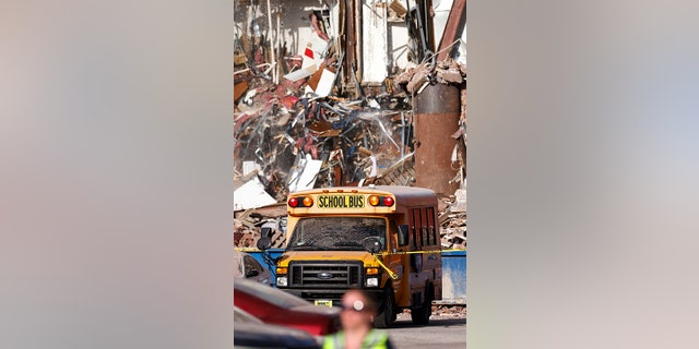 School bus in front of collapsed building
