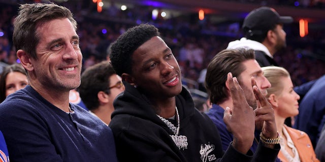 Willow Gardner and Aaron Rodgers sitting courtside