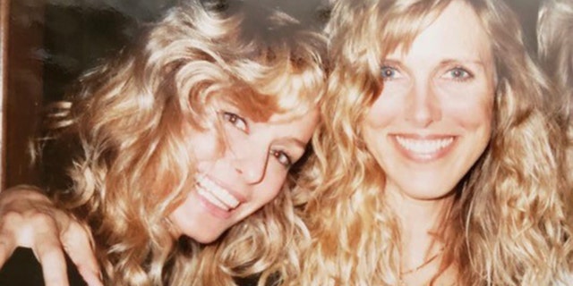 A close-up of Farrah Fawcett smiling and leaning into Alana Stewart