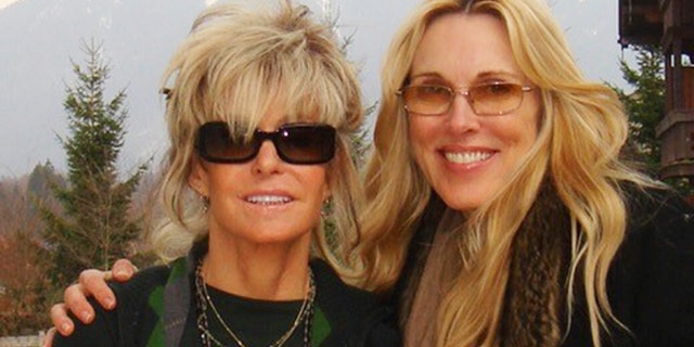 Farrah Fawcett and Alana Stewart wearing black while Farrah Fawcett wears black sunglasses