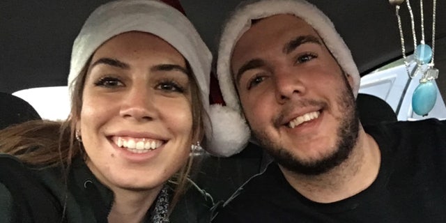 Amanda Hicks and her brother Eric Hicks wear Santa hats.
