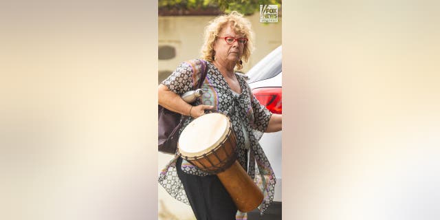 Joran van der Sloot's mom, Anita carries a drum in her right hand, a water bottle under her arm