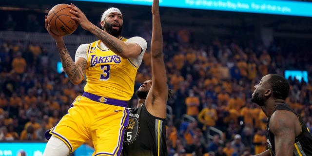 Anthony Davis drives over Kevon Looney