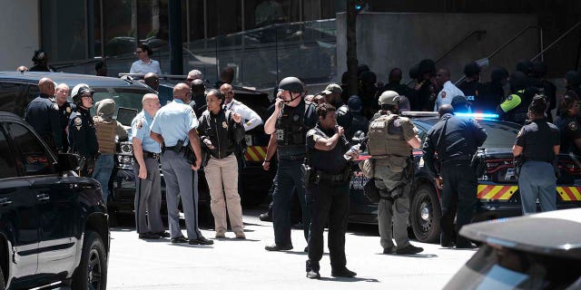 People stand outside a commercial building after a shooting, Wednesday, May 3, 2023, in Atlanta.
