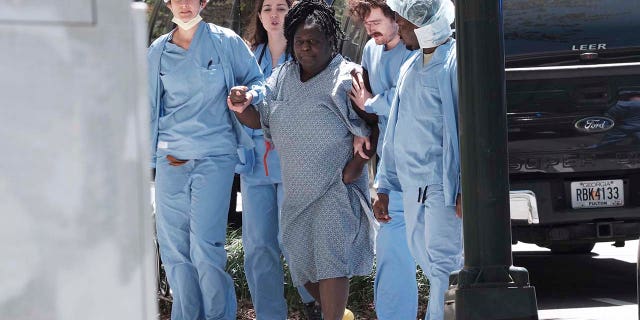 A medical patient is helped away from the scene of an active shooter on Wednesday, May 3, 2023 in Atlanta.