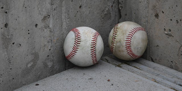 Two baseballs on ground