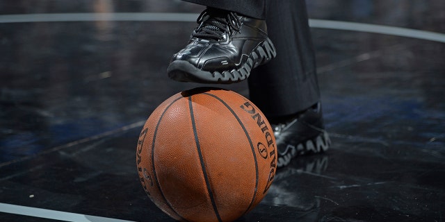 A referee steps on a ball