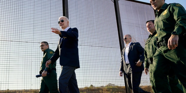 President Joe Biden walks along a stretch of the U.S.-Mexico border