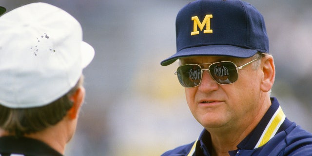 Bo Schembechler habla con un árbitro