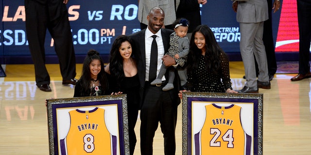 Kobe Bryant and his family pose with retired jerseys