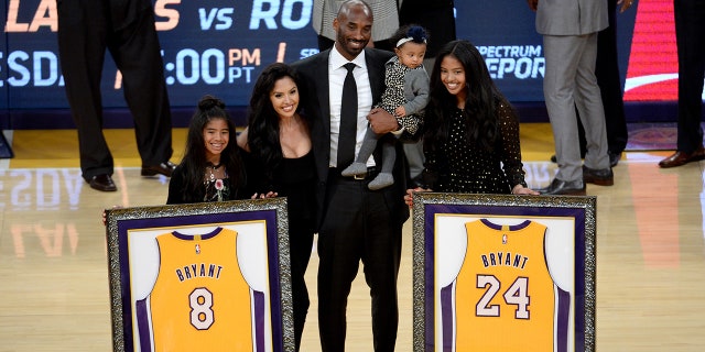 Kobe Bryant and his family pose with retired jerseys