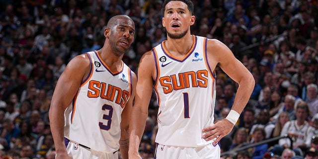 Chris Paul habla con Devin Booker