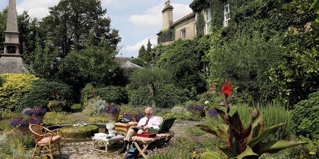 King Charles sitting in his garden