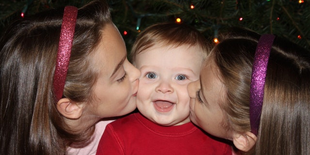 Ben Seitz gets kisses on the cheeks from his sisters