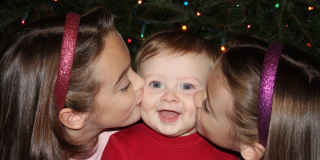 Ben Seitz gets kisses on the cheeks from his sisters